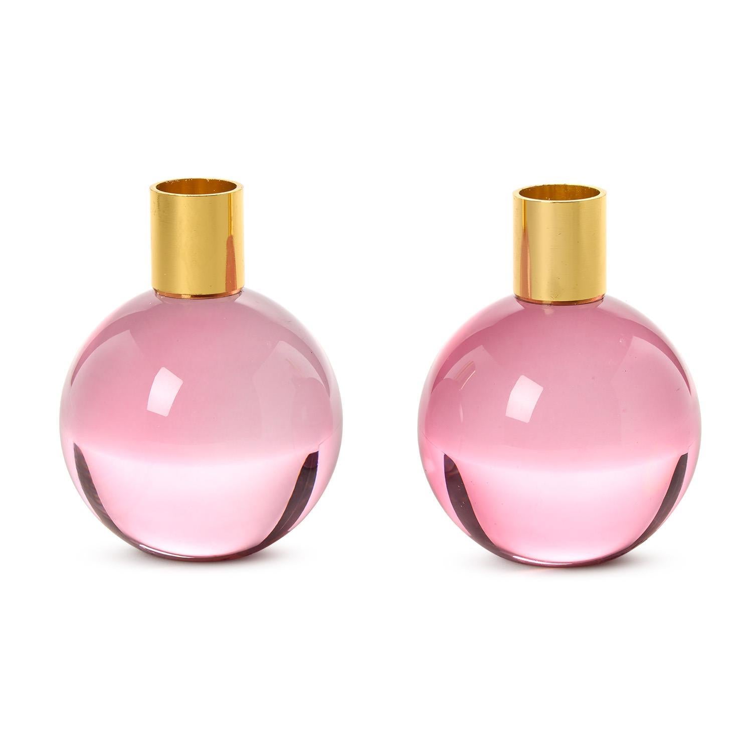 Two round pink glass candle holders with gold metal necks