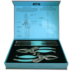 Product photograph of a Toadfish seafood tool set in an open teal and light blue box, featuring two crab cutters and four seafood forks with bright teal grips, accompanied by detailed diagrams of the tools on the box lid