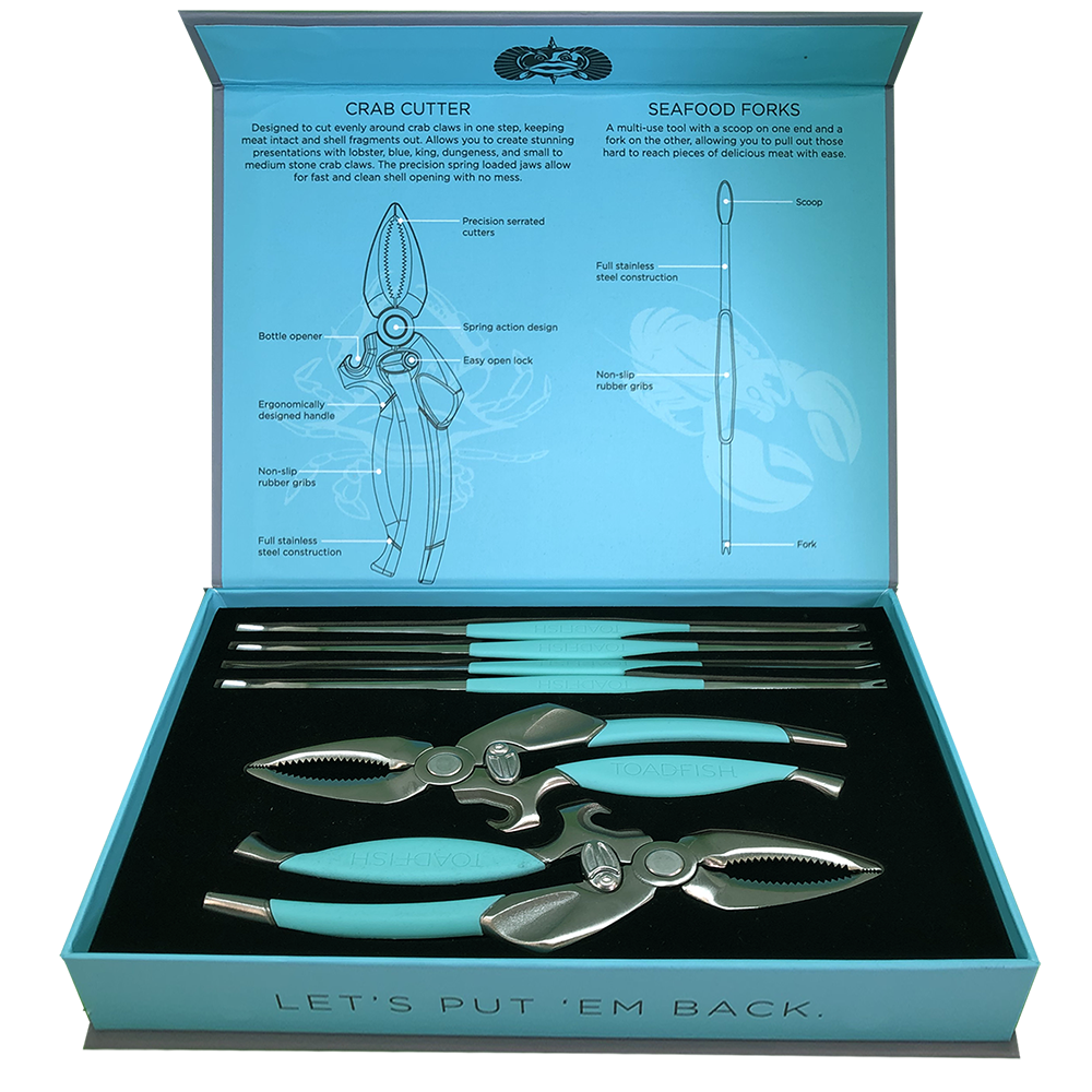 Product photograph of a Toadfish seafood tool set in an open teal and light blue box, featuring two crab cutters and four seafood forks with bright teal grips, accompanied by detailed diagrams of the tools on the box lid