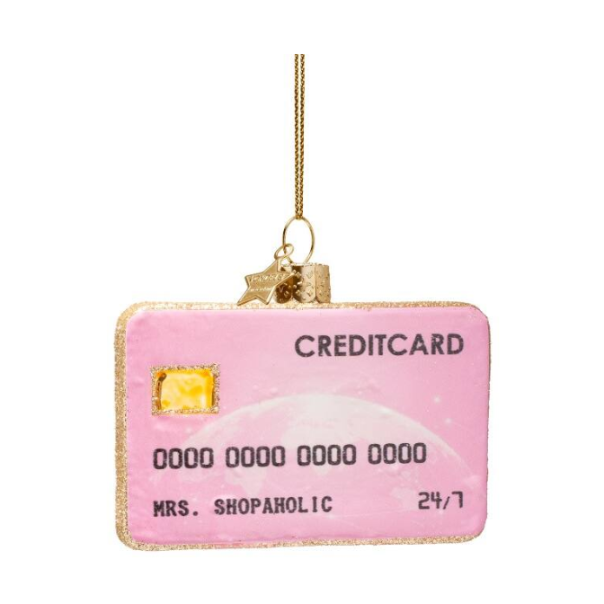 Glass ornament depicting a vibrant pink credit card with a glittery gold edge, a subtle planet graphic, the name MRS SHOPAHOLIC, and a gold star charm attached to its hanger