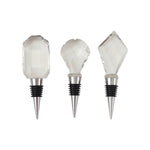 Three decorative wine stoppers with clear faceted crystal tops and silver metal bases