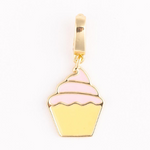 Gold enamel charm depicting a yellow cupcake with swirled pink frosting