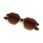 Tortoiseshell octagonal sunglasses featuring brown gradient lenses and gold metal frames displayed on a white background