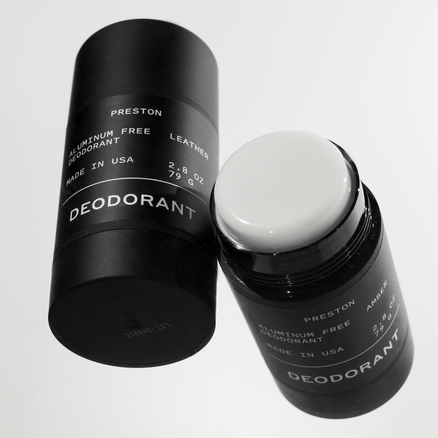 Two black Preston aluminum free deodorant sticks with white labels on a white background