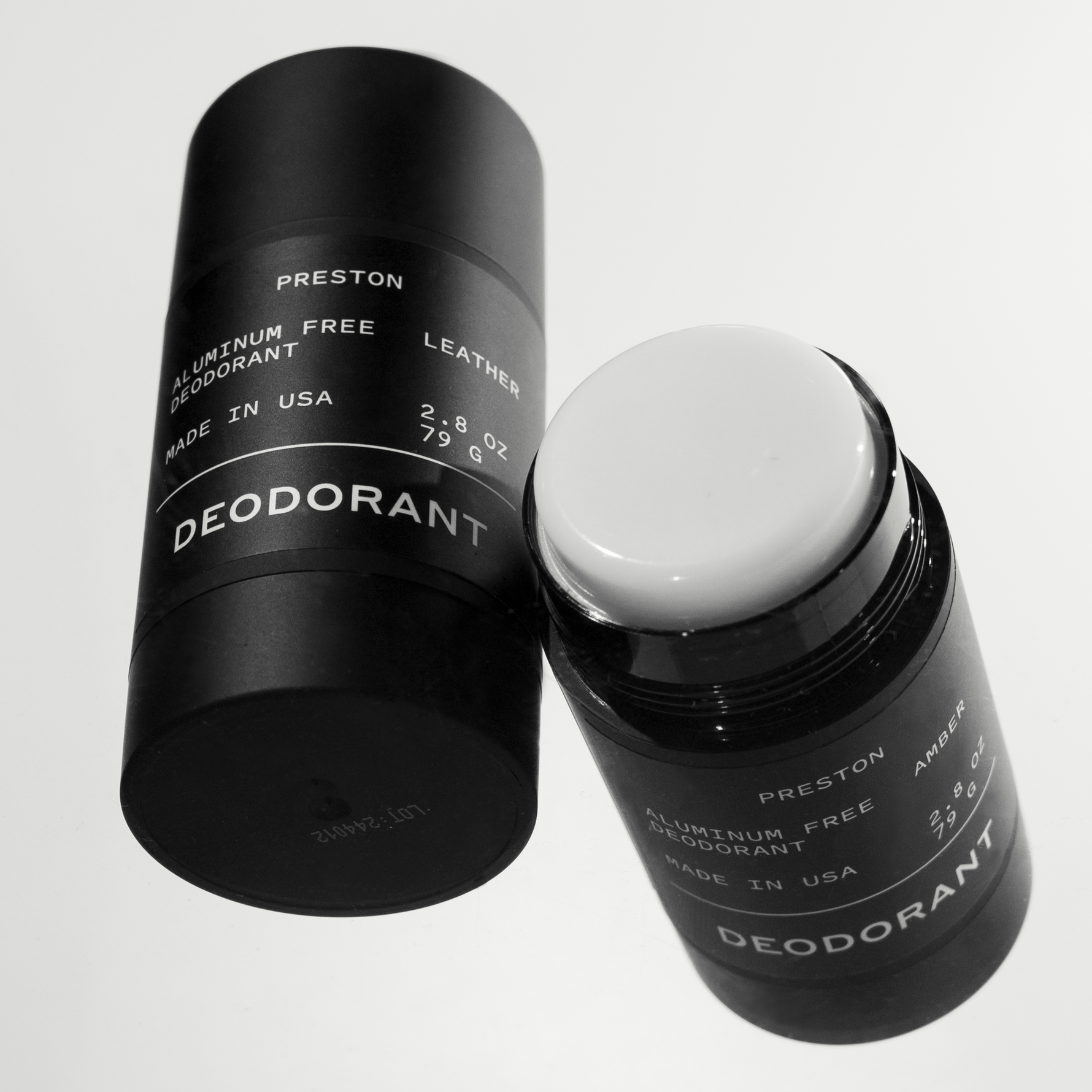 Two black Preston aluminum free deodorant sticks with white labels on a white background