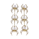 Gold-toned dangling earrings designed as three linked spiders each with a white pearl body and clear rhinestone-studded legs