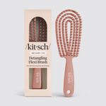 Product photography of a Kitsch Detangling Flexi Brush in a dusty rose color featuring a flexible arched design and white-tipped bristles, displayed alongside its coordinating light peach box packaging with a clear window and "Wet & Dry" text