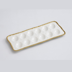 White rectangular ceramic serving tray featuring twelve glossy round wells and an elegant gold beaded rim