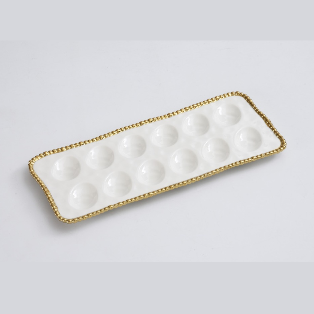 White rectangular ceramic serving tray featuring twelve glossy round wells and an elegant gold beaded rim
