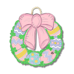 Digital illustration by DK designs of an Easter wreath with a large pink bow, pastel patterned eggs including stripes, polka dots, and zigzags, and a green leafy border on a beaded hanger