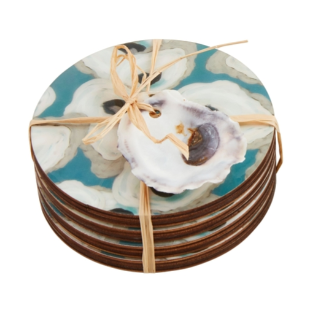 Stack of round coasters featuring a teal and white oyster pattern tied with natural raffia and a real oyster shell tag