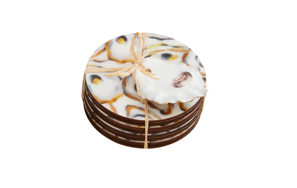 Set of round decorative coasters with an abstract oyster shell pattern in gold blue and brown stacked and tied with natural raffia ribbon featuring a realistic oyster shell on top with a subtle brown swirl