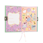 Whimsical children's diary open to reveal a lavender left page with a 'My name is' prompt and flying birds, opposite a peach right page adorned with die-cut stickers of ballerinas, a swan, and a fox