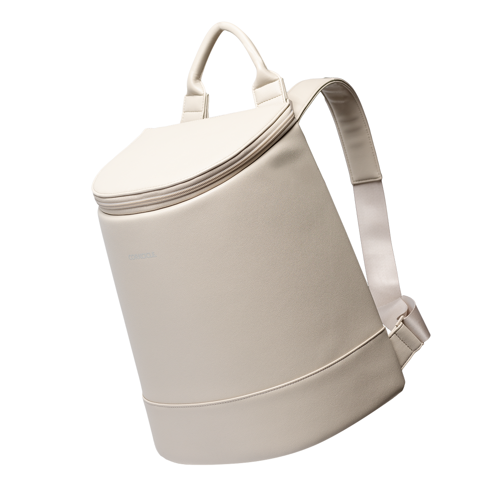 Cream colored Corkcicle backpack cooler with top handle and adjustable shoulder straps