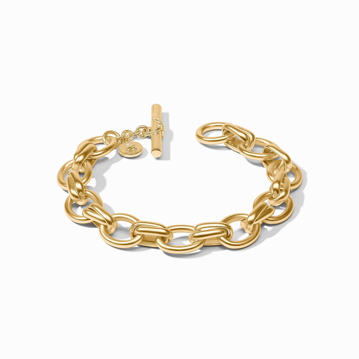 Gold chain link bracelet with a toggle clasp and small circular charm