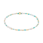A delicate beaded bracelet featuring shiny gold spherical beads, irregular white pearls, and small teal seed beads arranged in a flowing oval shape