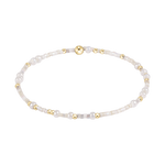 Jewelry beaded bracelet featuring varied natural pearls small gold beads tiny iridescent seed beads and a prominent central gold sphere