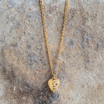 Gold chain necklace with a heart pendant featuring the word love in crystals