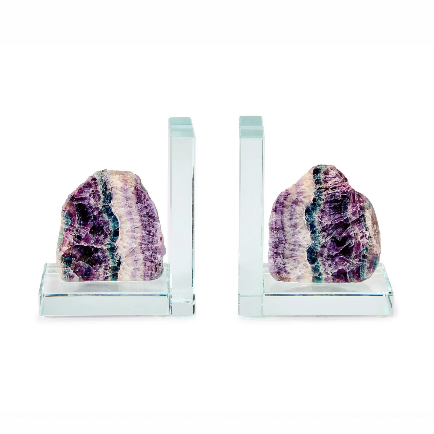 A pair of contemporary glass bookends each holding a rough cut banded fluorite crystal in vibrant purple green and white hues