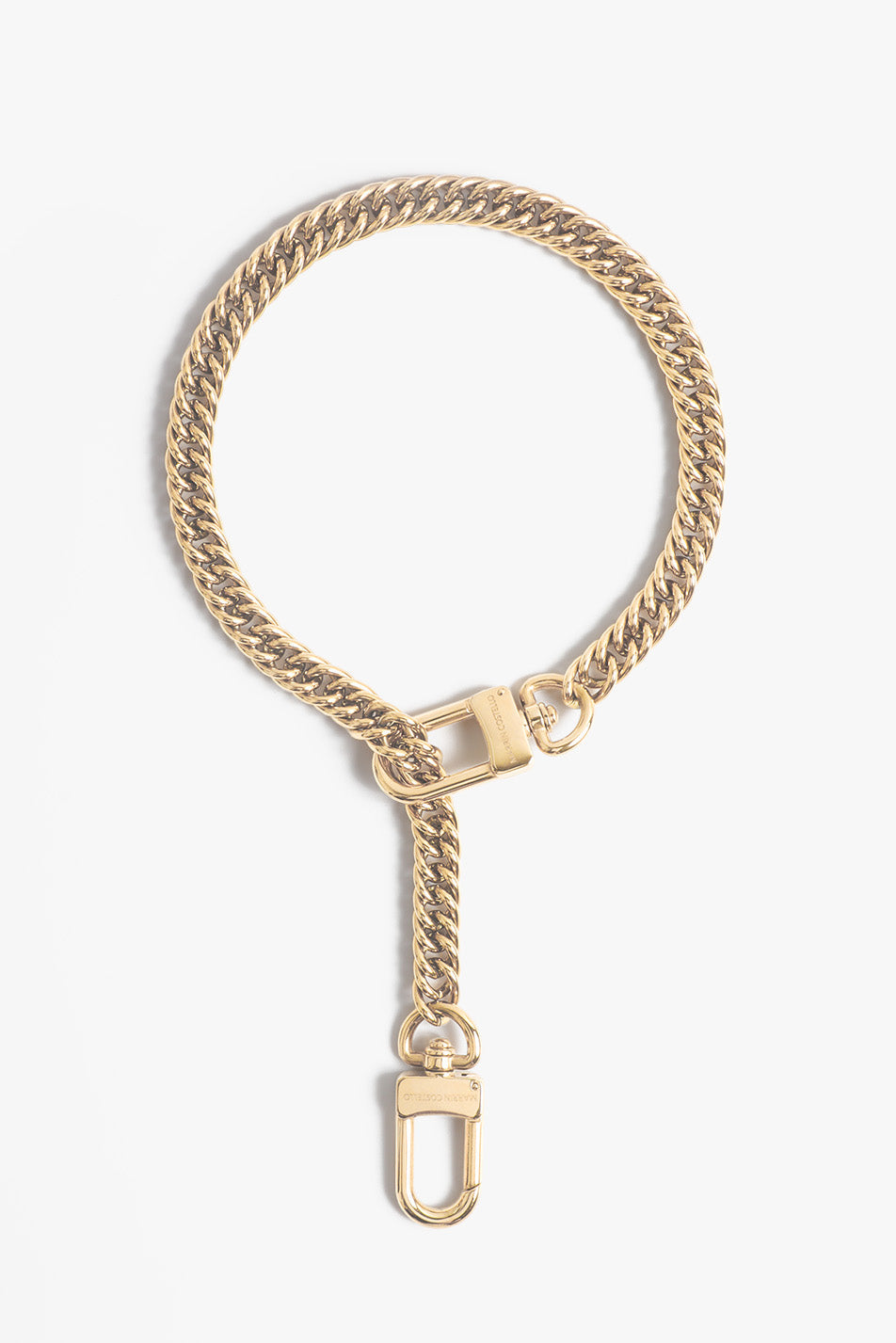 Gold-toned jewelry by Marvin Costello a chunky cuban link chain forms an elegant loop with a hanging D-ring clasp displaying brand engraving against a white studio background