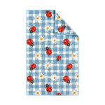 crae. patterned textile featuring red ladybugs with black spots and white daisies with yellow centers on a blue and white gingham background with a subtly folded top right corner