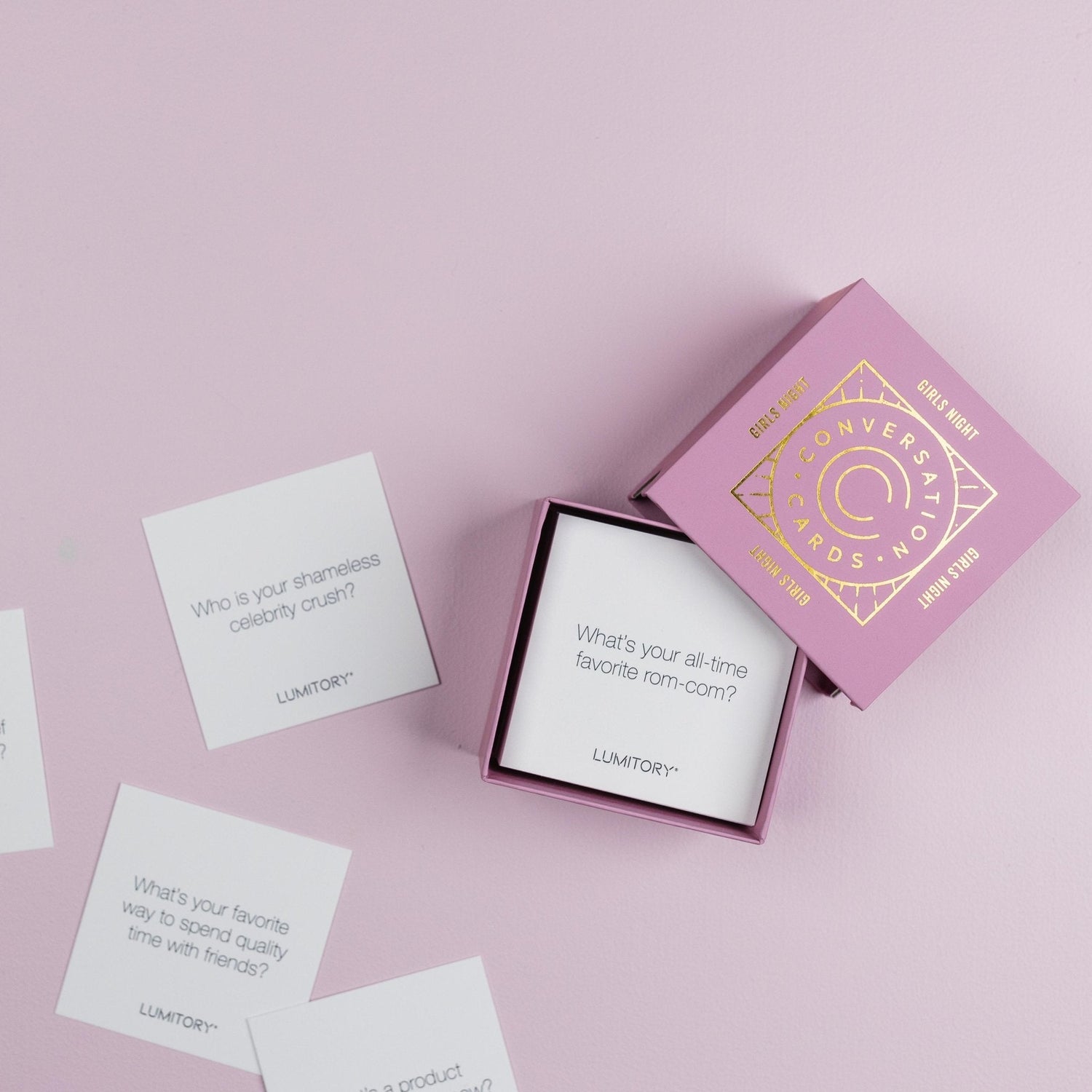 Lumitory Girls Night conversation card deck with open box and scattered prompt cards on a light purple background