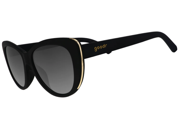 Black goodr cat-eye sunglasses with gradient gray lenses, gold trim accenting the frames, and the goodr logo in gold on the temple