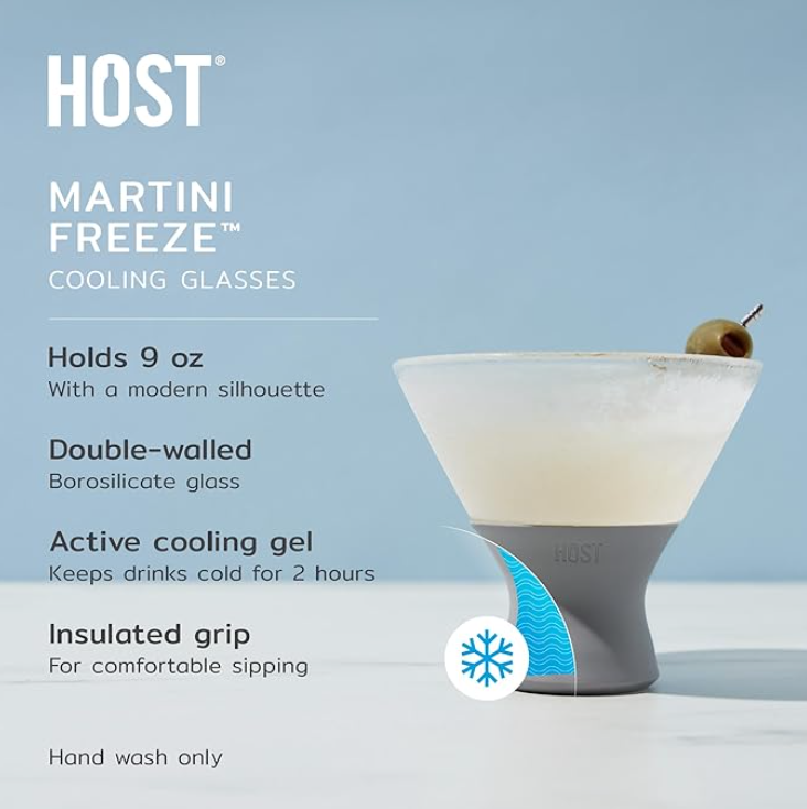 Product photography by HOST of a frosted Martini Freeze Cooling Glass with a grey insulated grip, containing a martini garnished with a green olive, on a light blue background featuring a blue snowflake graphic