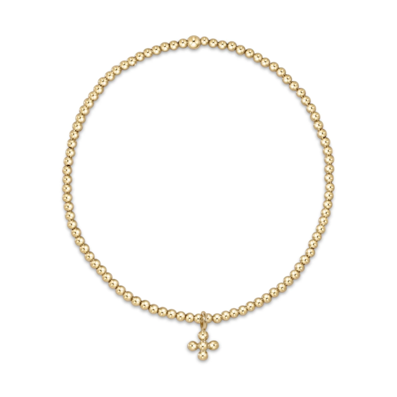 Polished gold beaded stretch bracelet adorned with a delicate four-ball cross charm
