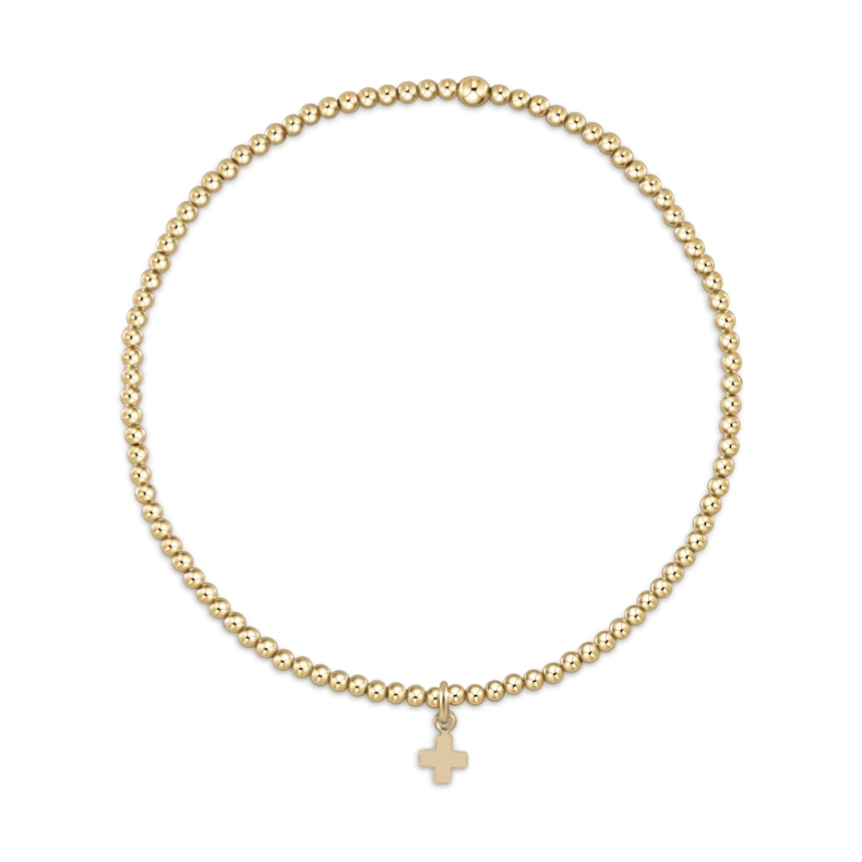 Gold beaded stretch bracelet with a small cross charm