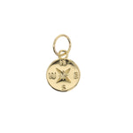 Gold charm a polished round compass rose design with embossed N S E W letters and a detailed textured starburst at its center