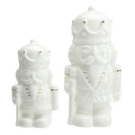 Two white ceramic nutcracker figurines with gold accents