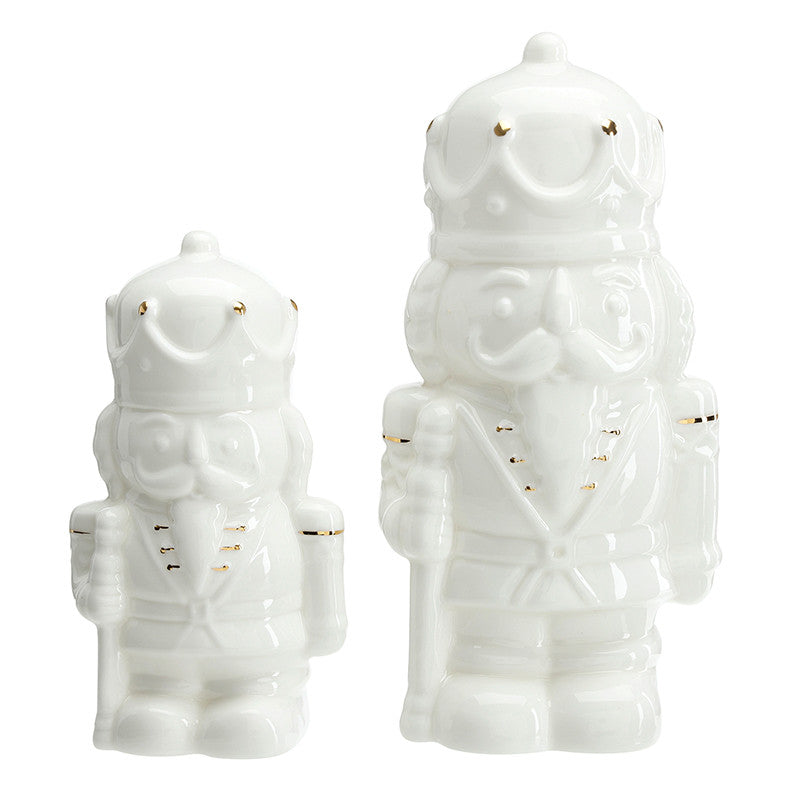 Two white ceramic nutcracker figurines with gold accents