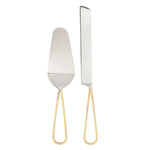 Silver cake serving set featuring a spatula and serrated knife with unique hammered gold teardrop handles on a white background