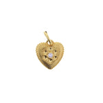 Gold jewelry heart pendant with a ribbed texture, featuring a central round brilliant diamond surrounded by starburst engravings