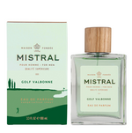 Studio photograph of Mistral Golf Valbonne perfume for men featuring a clear bottle with a textured wood cap and pale green liquid next to a box illustrated with a dark green golf course and cypress trees