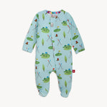 Baby onesie by Magnetic Me, a light blue sleeper featuring a whimsical golf course pattern with cartoon alligators wearing hats on green putting greens, numbered flags, and colorful crossed golf clubs