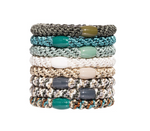 Eight L. Erickson elastic hair ties stacked vertically on a white background, displaying braided textures in a diverse color palette including olive green, vibrant teal, off-white, and multi-toned patterned designs