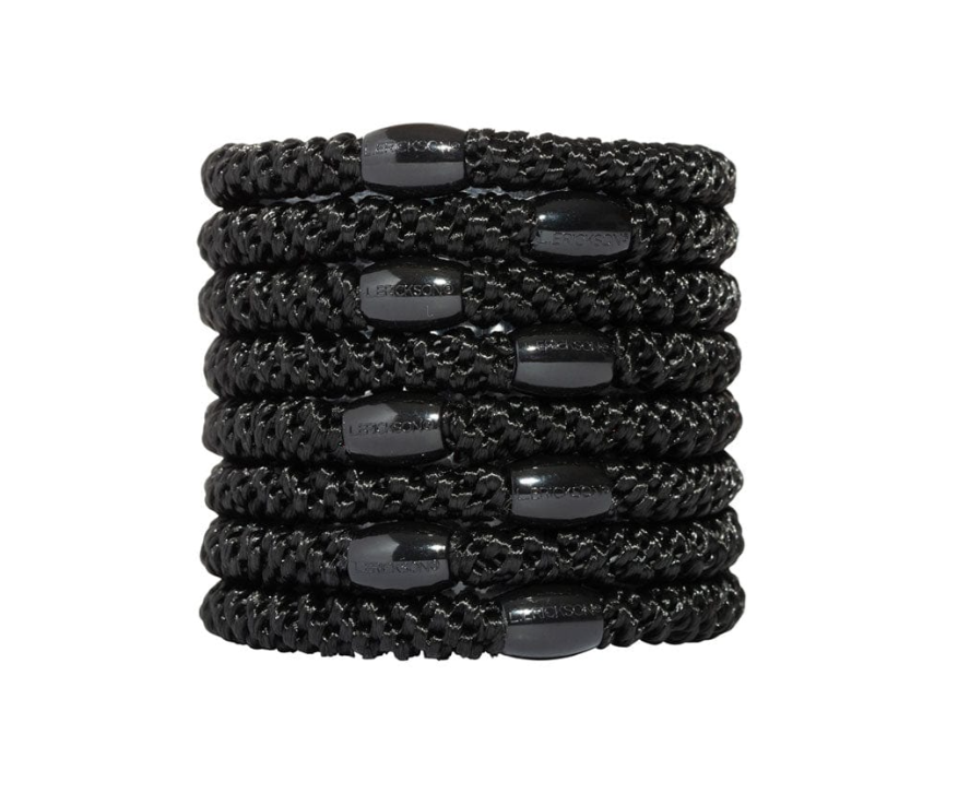 L. Erickson product image featuring a stack of seven black textured hair ties each with an oval black bead embossed with the L. ERICKSON brand name