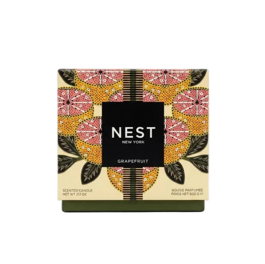 NEST NEW YORK Grapefruit Scented Candle box featuring a vibrant folk-art inspired pattern of pink grapefruit slices and yellow-orange textured segments, accented by a dark green base and a central black label with white text
