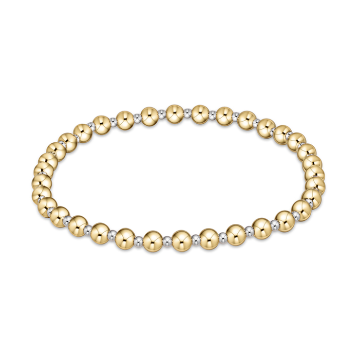 Bicolor beaded bracelet on a white background composed of alternating shiny gold and silver small spherical beads