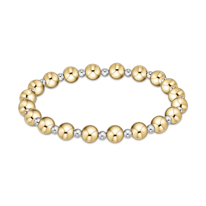 Product shot of an elegant stretch bracelet featuring alternating polished spherical gold and silver beads on a clean white background