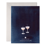 Greeting card with two champagne coupes on a dark blue background and a light grey envelope