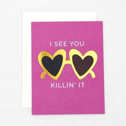 Greeting card with a magenta background featuring gold foil heart-shaped sunglasses with black lenses and white text 'I SEE YOU KILLIN' IT'