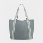A grey textured faux leather Katie Loxton tote bag featuring light blue and cream striped shoulder straps on a plain white background