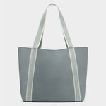 Katie Loxton product photo of a blue-grey pebbled faux leather tote bag on a plain background featuring two-toned light blue and cream webbing straps and subtle gold brand lettering