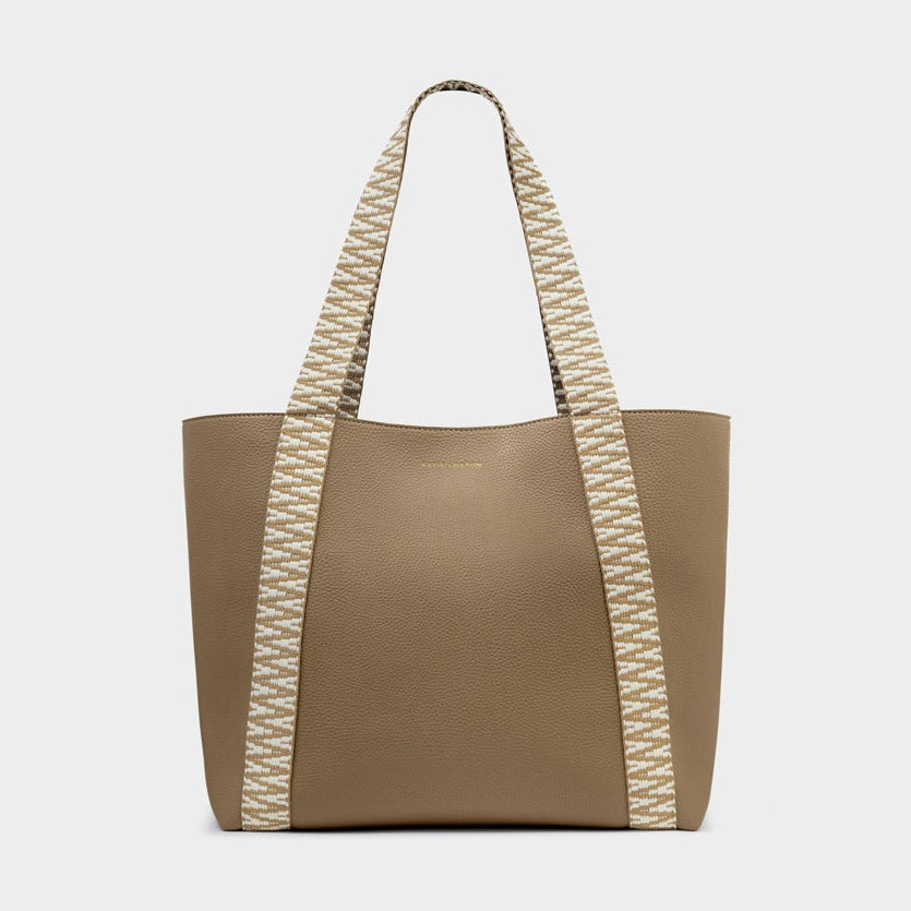 Digital photograph by Status Anxiety of a taupe pebbled leather tote bag featuring wide woven white and beige geometric patterned straps and a subtle debossed logo
