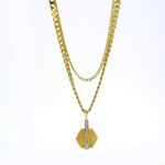 Gold-tone metal jewelry layered necklace showcased on a white background featuring mixed curb and rope chains with a fan-textured hexagonal pendant highlighted by a vertical row of sparkling clear crystals