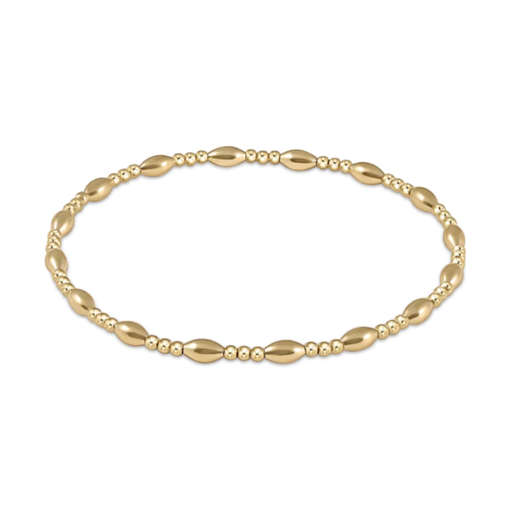 Gold beaded bracelet featuring alternating polished oval and small round beads with a lustrous finish on a white background