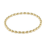 Gold beaded bracelet featuring uniform oval rice-shaped beads in a warm golden hue